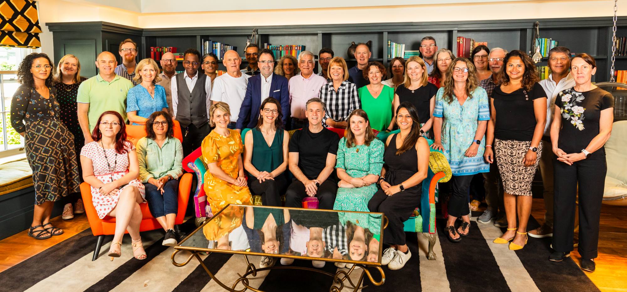 Group of professionals seated in a colorful office setting, showcasing corporate photography.